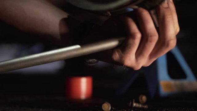 Close up of mechanic hands, swingarm regulation