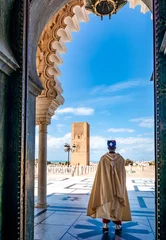 Foto op Plexiglas Marokko Wacht soldaat in klederdracht bij de ingang van Mausoleum van Mohammed V en plein met Hassan toren in Rabat op zonnige dag. Locatie: Rabat, Marokko, Afrika