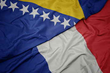 waving colorful flag of france and national flag of bosnia and herzegovina.