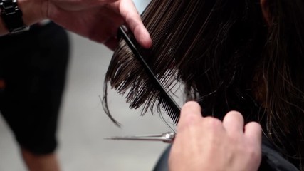 Barber is cutting girl's hair