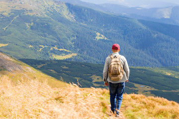 guy with a backpack travels in the mountains