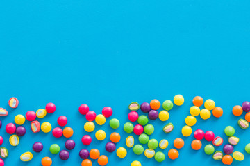 Candies and dots for party design on blue background top view copyspace