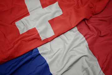 waving colorful flag of france and national flag of switzerland.
