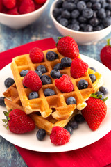 Two Classic Berry Waffles on a Rustic Blue Wood Table