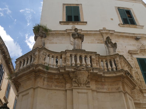 Lecce – Piazza Duomo propylaea. Propylaea in the entrance of Piazza Duomo are two opposite balconies in baroque style supporting the statues of  st Oronzo, Irene and Venera and of the church's Father 