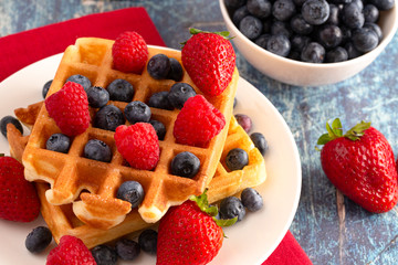 Two Classic Berry Waffles on a Rustic Blue Wood Table