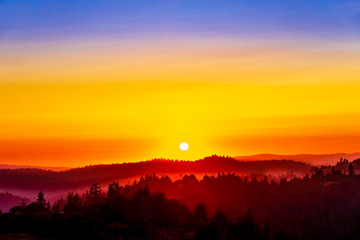 Fototapeta premium Layers of Silhouetted Hills, Forests, Trees, at Sunset
