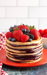 Berry Pancakes with Compote Spread on a Rustic Blue Wood Table