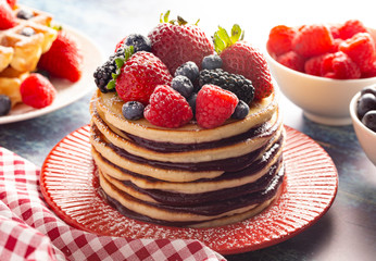 Berry Pancakes with Compote Spread on a Distressed Blue Wood Table