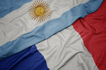 waving colorful flag of france and national flag of argentina.