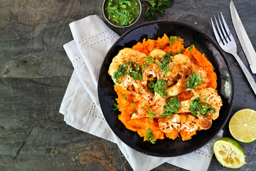 Cauliflower steak with sweet potato mash. Top view scene on a slate background. Healthy eating, plant based meat substitute concept.