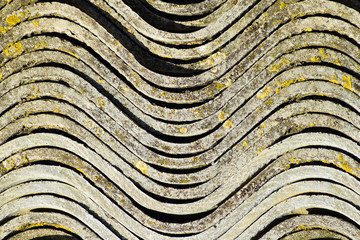 Corrugated slate lies in a pile, side view background texture of slate.