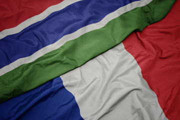 waving colorful flag of france and national flag of gambia.