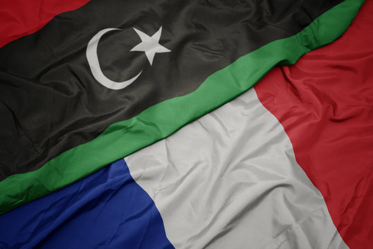 waving colorful flag of france and national flag of libya.