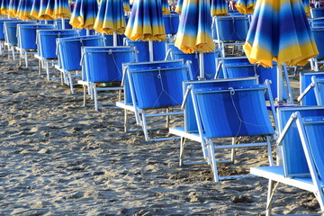 Liegestühle und Sonnenschirme geschlossen am frühe Morgen an der adriatischen Küste