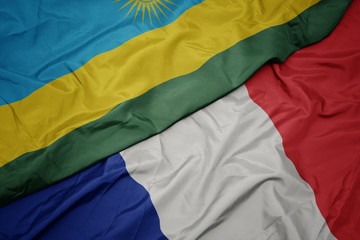 waving colorful flag of france and national flag of rwanda