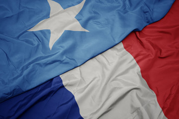 waving colorful flag of france and national flag of somalia.