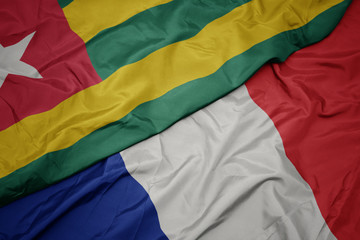 waving colorful flag of france and national flag of togo.