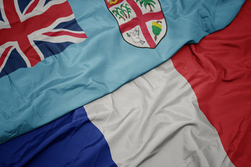 waving colorful flag of france and national flag of Fiji ,