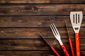 Tongs, fork, spatula for barbecue and grill on wooden background top view space for text
