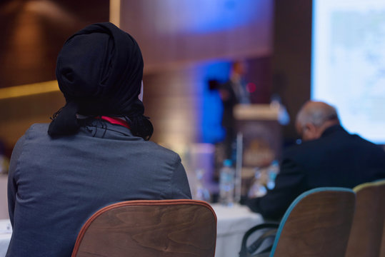 Business woman as leader speaking at Conference. Audience at the conference room or hall , representing model of economic development and startup business and interreligious relations.