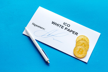 Initial coin offering ICO white paper, bitcoin, pen on blue background