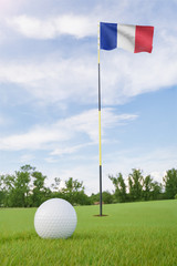 Obraz premium France flag on golf course putting green with a ball near the hole