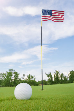United States flag on golf course putting green with a ball near the hole