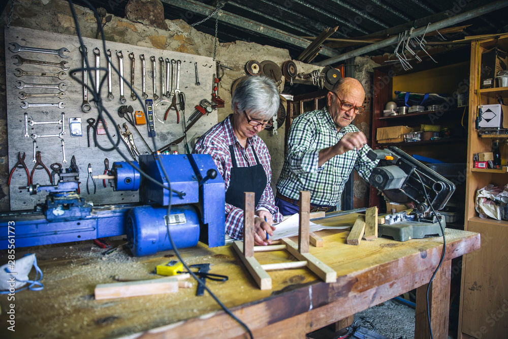 Wall mural Senior couple working in a carpentry workshop