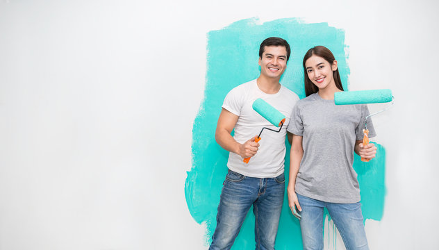 Portrait Of Happy Smiling Asian Couple Renovating Painting Wall House. Mother Father Repairing Paint Wall At Home. Man And Woman Together Love Lifestyle Concept With Copy Space.