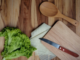 Lettuce, knife, butcher, spoon, on a wooden table