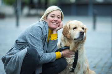 Vilnius- Lithuania, May 6, 2019: Mature Caucasian Female with Her Pale Dog Outdoors in Vilnius, May 6, 2019