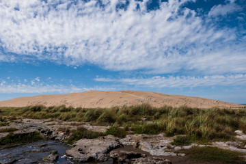 Fototapeta na wymiar Stone river next to sand dune