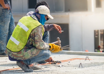 Welder man welding steel bars the supporting the precast concrete wall, worker with unprotected and unsafety.