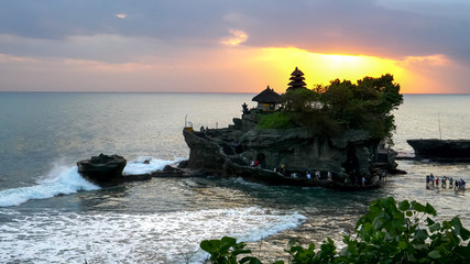 tourists wading out to tanah lot temple at sunset © chris
