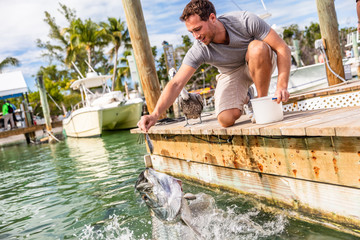 Tarpon fish feeding in the keys, Florida, Summer travel lifestyle tourism. American man having fun...
