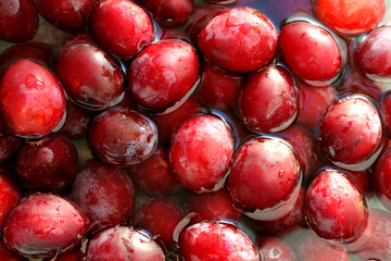 Ripe juicy plums lie in the water