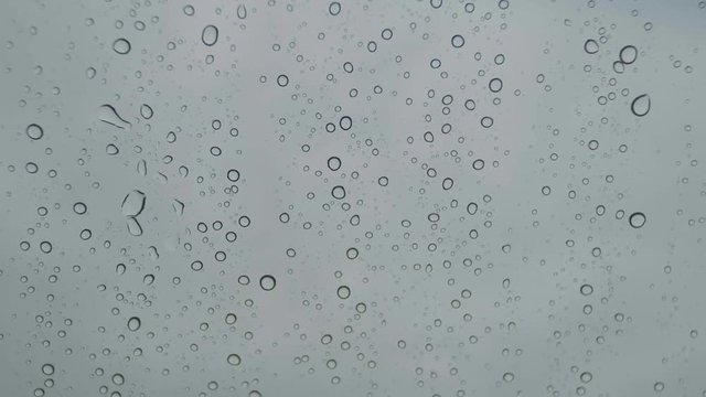 Raindrops on car windshield slow motion