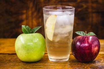 Apple spritzer (apfelschorle) pitcher, Glass pitcher of homemade spritzer served with crushed ice and apple slices. Jug full of non-alcoholic sparkling and cold carbonated apple juice.
