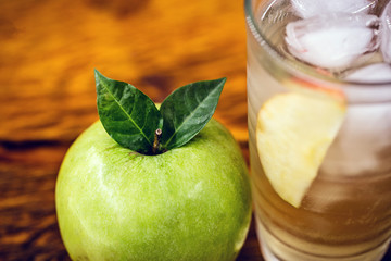 Apple spritzer (apfelschorle) pitcher, Glass pitcher of homemade spritzer served with crushed ice and apple slices. Jug full of non-alcoholic sparkling and cold carbonated apple juice.