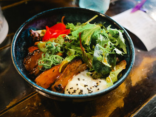 Japanese ramen with spoiled egg and fried pork and vegetables bowl inside restaurant