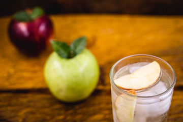 Apple spritzer (apfelschorle) pitcher, Glass pitcher of homemade spritzer served with crushed ice and apple slices. Jug full of non-alcoholic sparkling and cold carbonated apple juice.