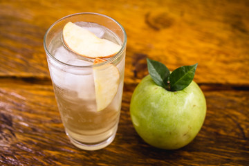 Apple spritzer (apfelschorle) pitcher, Glass pitcher of homemade spritzer served with crushed ice and apple slices. Jug full of non-alcoholic sparkling and cold carbonated apple juice.