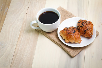 Croissant and coffee  isolated on wood table