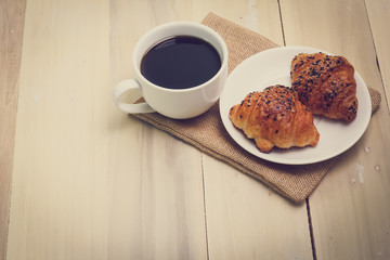 Croissant and coffee  isolated on wood table