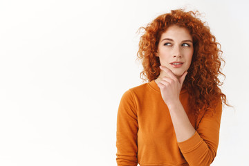 Hmm interesting. Curious cunning good-looking redhead girl planning perfect scheme, rub chin, squinting suspicious and thoughtful peek left, thinking, pondering between nice choices - obrazy, fototapety, plakaty
