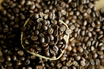 Coffee beans in the basket on wooden background , soft focus , blured