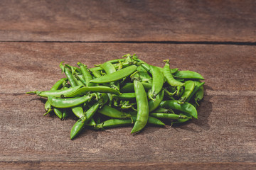 Fresh green peas or beans on wooden table