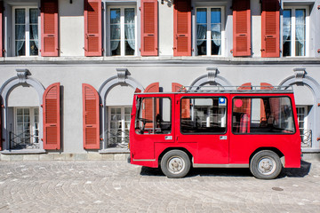 Fototapeta na wymiar A Red taxi in front of train station in Zermatt, Switzerland