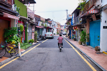 Fototapeta na wymiar man on a bicycle in a street of Malacca, Malaysia 